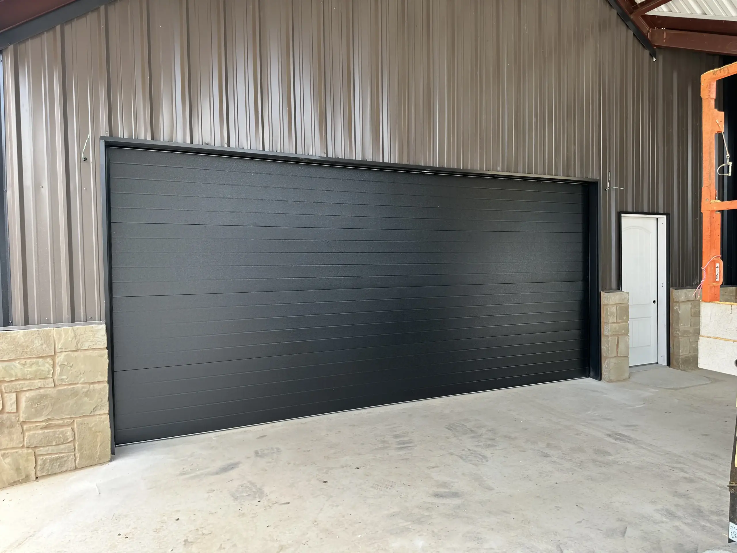 high-lift-garage-door-ext side mount Liftmaster opener installed on black commercial garage door